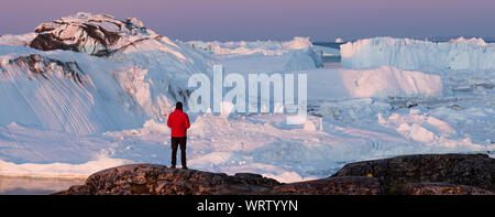 Dans l'Arctique aventure voyage wanderlust paysage nature d'icebergs - office de personne à la vue à du Groenland - icefjord photo aérienne. L'homme par l'état des glaces et des icebergs, Ilulissat. Banque D'Images