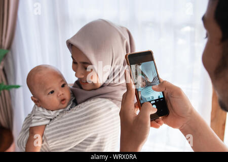 Papa prendre une photo de sa femme carrying baby boy Banque D'Images