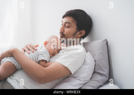 Mignon bébé garçon endormi sur la poitrine du père Banque D'Images