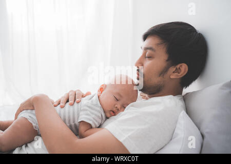 Papa avec son jeune garçon endormi sur sa poitrine Banque D'Images