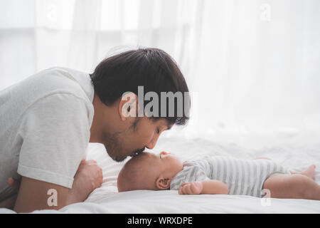 Asian papa embrasser son petit garçon sur le front Banque D'Images