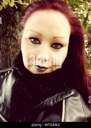 Portrait Of Mid adult Woman Wearing Leather Jacket Standing By Tree