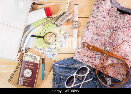 Concept de voyage avec la collection de costumes et d'accessoires féminins sur table en bois vintage Banque D'Images