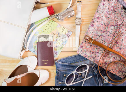 Concept de voyage avec la collection de costumes et d'accessoires féminins sur table en bois vintage Banque D'Images