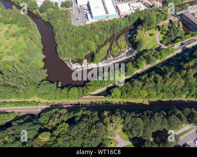 Photo aérienne d'une petite cascade avec des arbres verts autour d'elle prises dans la ville de Leeds West Yorkshire Banque D'Images