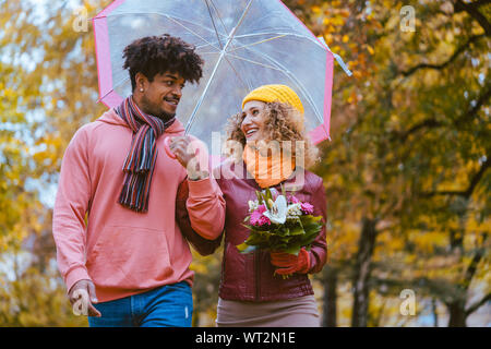 Couple avec différentes ethnies ayant une promenade dans le parc en automne Banque D'Images