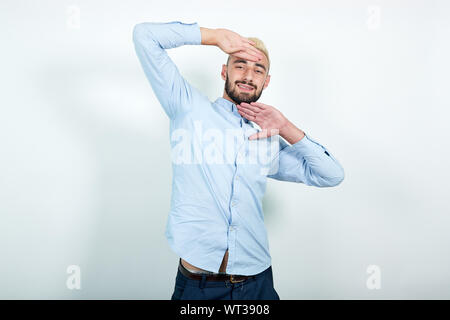 L'homme aux cheveux blonds, barbe noire sur fond blanc isolé montre les émotions Banque D'Images