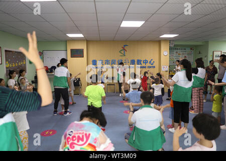 (190911) -- CHONGQING, le 11 septembre 2019 (Xinhua) -- les enseignants en éducation spéciale amener les élèves à faire des exercices pendant la pause à Chongqing Centre de réadaptation et de formation de la Jacinthe dans le sud-ouest de la municipalité de Chongqing en Chine, le 10 septembre, 2019. Né en 1990, enseignant de l'Ran Xianxi et Wang Huajun passé leur première journée des enseignants à Chongqing Centre de réadaptation et de formation Jacinthe mardi, après avoir quitté leurs emplois bien payés dans d'autres institutions de formation il y a deux mois. En combinant leur expérience professionnelle de psychologie appliquée et dévouement, leur travail acharné a été hautement Banque D'Images