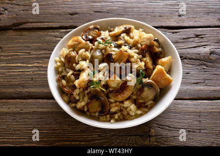 Risotto aux champignons et morceaux de viande de poulet sur la table en bois Banque D'Images