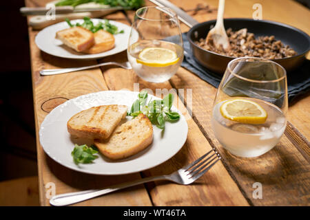 Ragoût de champignons dans la poêle avec du pain grillé et le persil sur table en bois Banque D'Images