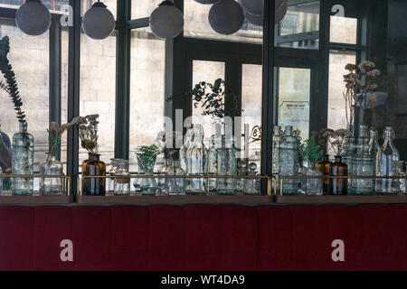 Rennes, Bretagne / France - 26 août 2019 : Bouteilles en verre décoratif line le mur dans un petit restaurant à Rennes avec des miroirs aux murs et vele Banque D'Images