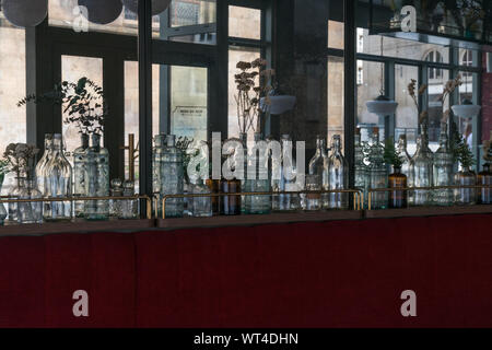 Rennes, Bretagne / France - 26 août 2019 : Bouteilles en verre décoratif line le mur dans un petit restaurant à Rennes avec des miroirs aux murs et vele Banque D'Images