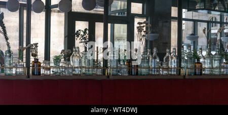 Rennes, Bretagne / France - 26 août 2019 : Bouteilles en verre décoratif line le mur dans un petit restaurant à Rennes avec des miroirs aux murs et vele Banque D'Images