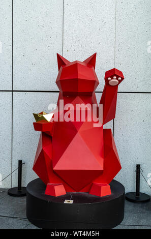 Maneki neko rouge-fortune cat porte bonheur pour propriétaire de l'entreprise lorsqu'ils sont placés à l'extérieur store Banque D'Images