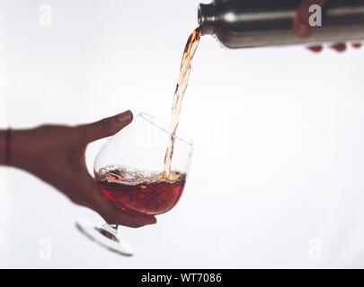 Le vin. Verser le vin rouge dans le verre de vin sur fond blanc. Vin rose pour de la bouteille Banque D'Images