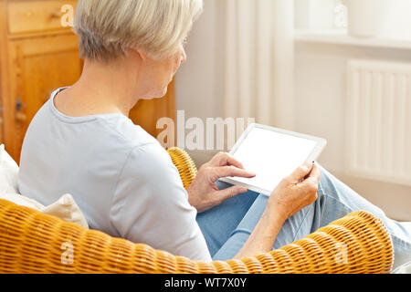 La technologie et les personnes âgées, senior concept woman with tablet computer at home, en touchant l'écran vide Banque D'Images