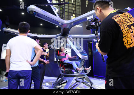 (190911) -- HANGZHOU, le 11 septembre 2019 (Xinhua) -- Un visiteur (2e R) expérience d'un aéronef habité à une exposition technique salon transformé d'une vieille usine de chaudières à Hangzhou, capitale de la Chine de l'est la province du Zhejiang, le 11 septembre 2019. La quatrième Taobao Bouilloire Festival, un grand événement de Alibaba détient chaque année pour présenter la dernière création de jeunes designers chinois, aura lieu du 12 au 25 septembre. Plus de 1 000 produits provenant de quelque 400 boutiques Taobao seront exposés à cet événement. (Xinhua/Huang Zongzhi) Banque D'Images