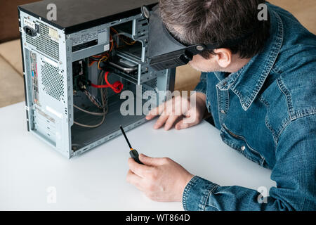 Réparateur est de démonter l'ordinateur personnel. Il est ingénieur et de diagnostic pc cassé fixation en atelier. Atelier de réparation électronique, technologie, rénovation Banque D'Images