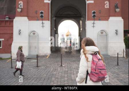 Jeune fille de tourisme avec sac à dos à la recherche au Kremlin gates debout sur la Place Rouge avec vieille femme au foulard par marche sur le pavage Banque D'Images