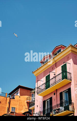 Maison de vacances d'été - maisons peintes de couleurs vives et de mouettes sur le front d'Imperia sur la Riviera Italienne en été. Banque D'Images