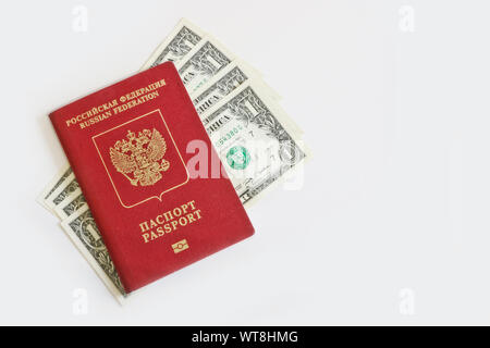 Le passeport russe des affaires étrangères, se trouve au sommet d'un-dollar bills sur fond clair. Voyageant à l'étranger, budget vacances. Banque D'Images