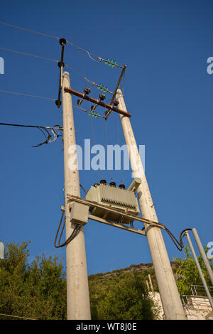 Entre deux grands poteaux transformateur haute tension avec l'approvisionnement en électricité. Banque D'Images