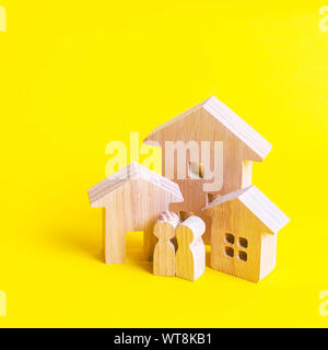 Trois maisons et des gens sur un fond jaune. Achat et vente de biens immobiliers, de la construction. Appartements et immeubles d'habitation dans une ville ou un ensemble Banque D'Images