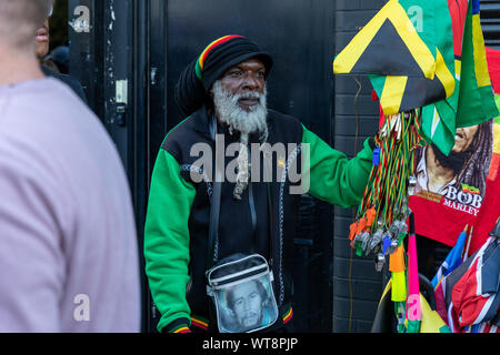 Un homme vend des accessoires de carnaval pendant le Carnaval de Hackney en septembre 2019 Banque D'Images