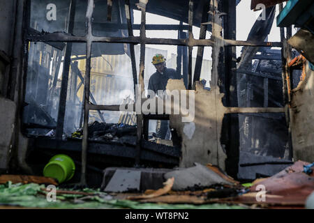 Manille, Philippines. Sep 11, 2019. Un pompier essaie d'éteindre un incendie dans un quartier résidentiel à Manille, Philippines, le 11 septembre 2019. Trois personnes sont mortes, dont deux enfants de quatre et cinq ans, et deux autres blessées dans un incendie qui a frappé une zone résidentielle de la capitale des Philippines, Manille, le mercredi, le bureau local de la protection contre les incendies a dit. Credit : Rouelle Umali/Xinhua/Alamy Live News Banque D'Images