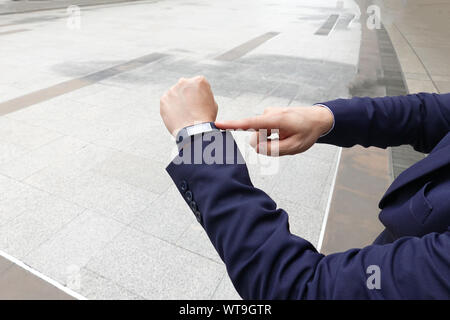 Portrait La main à l'aide de Smart Watch contre l'arrière-plan de la ville Banque D'Images