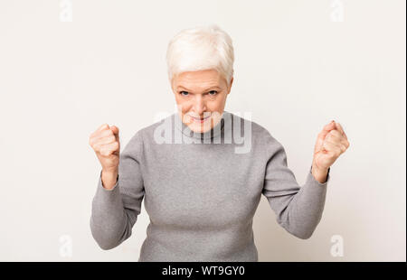 Vieille Femme en colère menace quelqu'un poing levé avec Banque D'Images