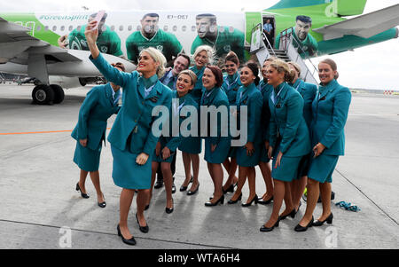 L'équipage de cabine d'Aer Lingus selfies prendre une avec l'avion à l'aéroport de Dublin après l'équipe monte à bord de l'Irlande à partir pour la Coupe du Monde de Rugby 2019 au Japon. Banque D'Images