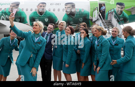 L'équipage de cabine d'Aer Lingus selfies prendre une avec l'avion à l'aéroport de Dublin après l'équipe monte à bord de l'Irlande à partir pour la Coupe du Monde de Rugby 2019 au Japon. Banque D'Images