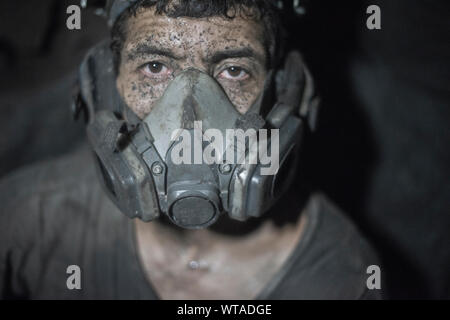 Miner avec un masque anti-poussière à l'intérieur de la mine quartzo Banque D'Images