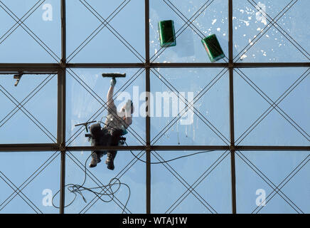 Dresde, Allemagne. 10 Sep, 2019. Un spécialiste du bâtiment de verre et de nettoyeur de la société Purel de Dresde est le nettoyage de la verrière du World Trade Center (WTC) à une hauteur de 27 mètres. Le toit en verre incurvé a une superficie d'environ 2 700 mètres carrés. Crédit : Robert Michael/dpa-Zentralbild/ZB/dpa/Alamy Live News Banque D'Images