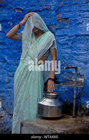 Femme portant du Rajasthan sari l'eau dans un robinet Banque D'Images