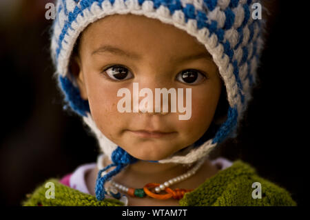 Mignon petit enfant portant un chapeau de laine et de l'habillement traditionnel Banque D'Images