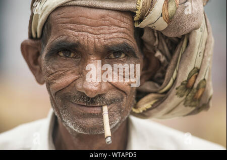 L'homme hindou vieux fumeurs de cigarettes de paille Banque D'Images