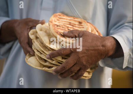 Homme portant une bande d'czhot ou girda, pain traditionnel kashmiri Banque D'Images