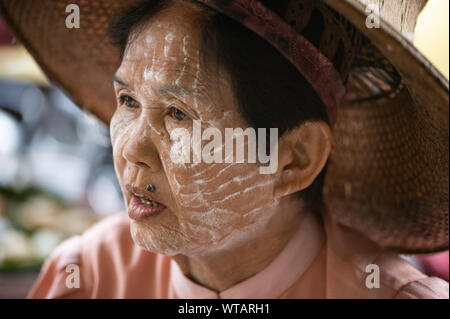 Vieille dame à l'aide de Thanaka, un cosmétique Faciale birman traditionnel Banque D'Images