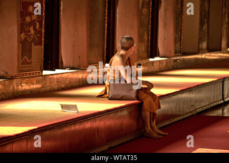 Moine assis à l'intérieur d'un temple à Bangkok Banque D'Images