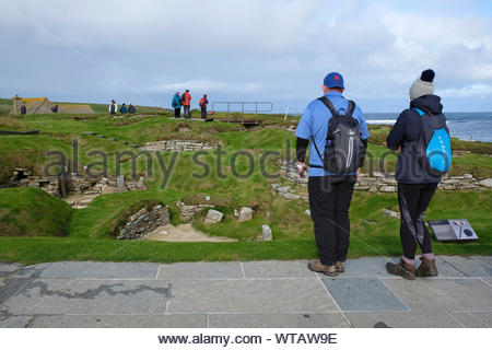 Les touristes visitant Skara Brae, un site néolithique en pierre, situé dans la partie continentale de l'Orkney, Ecosse Banque D'Images