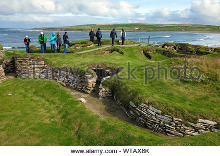 Les touristes visitant Skara Brae, un site néolithique en pierre, situé dans la partie continentale de l'Orkney, Ecosse Banque D'Images