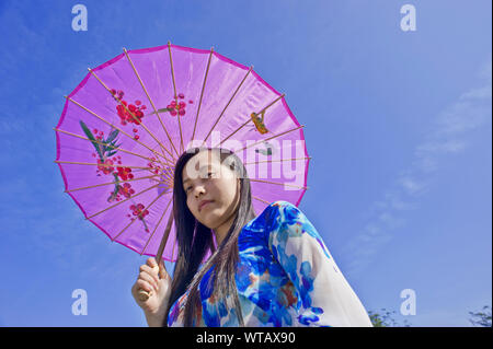 Le port touristique vietnamien Ao dai robe avec de l'huile-parapluie de papier Banque D'Images