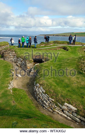 Les touristes visitant Skara Brae, un site néolithique en pierre, situé dans la partie continentale de l'Orkney, Ecosse Banque D'Images