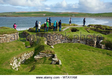 Les touristes visitant Skara Brae, un site néolithique en pierre, situé dans la partie continentale de l'Orkney, Ecosse Banque D'Images