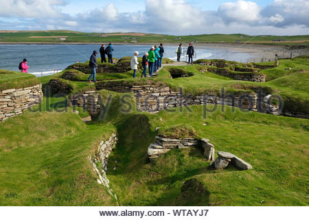 Les touristes visitant Skara Brae, un site néolithique en pierre, situé dans la partie continentale de l'Orkney, Ecosse Banque D'Images