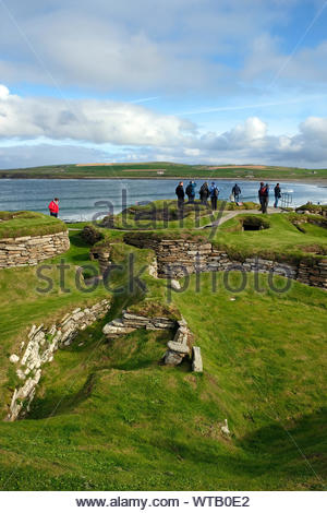 Les touristes visitant Skara Brae, un site néolithique en pierre, situé dans la partie continentale de l'Orkney, Ecosse Banque D'Images