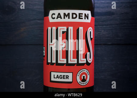 Londres - 3 septembre 2019 : Camden Hells Craft Beer bottle sur fond de bois foncé Banque D'Images