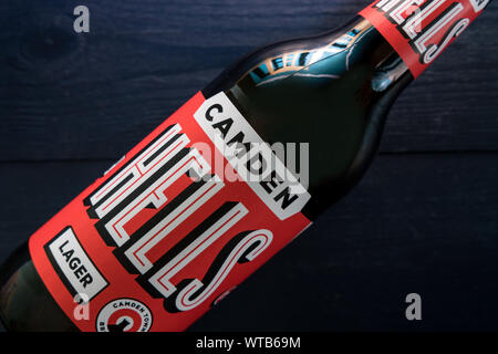 Londres - 3 septembre 2019 : Camden Hells Craft Beer bottle sur fond de bois foncé Banque D'Images